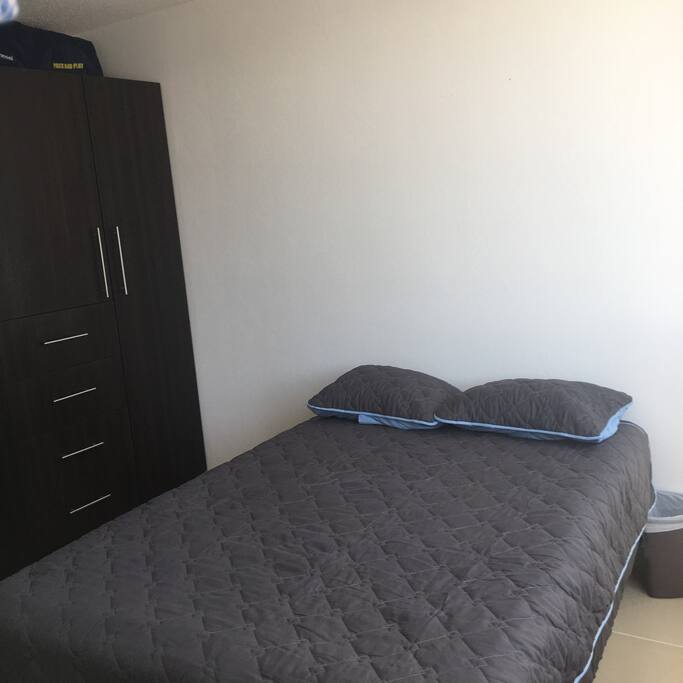 Recamara con closet y cama.