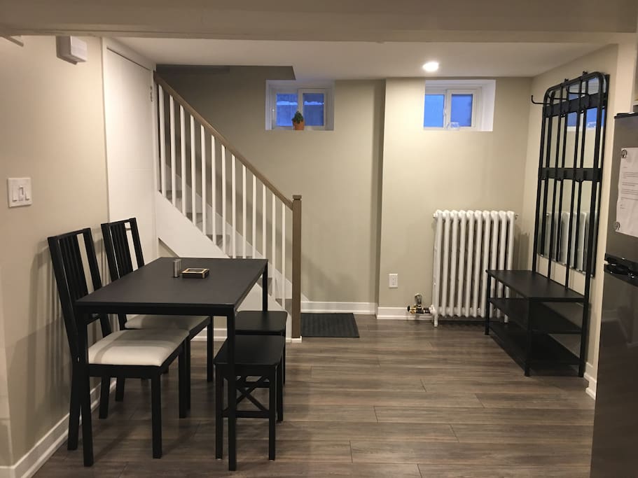 Coat and shoe rack at entrance followed by a dining table that seats four.