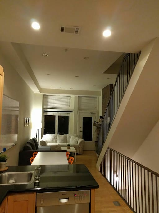 Living room, fireplace, projector, door to the outside, open kitchen, and a bathroom