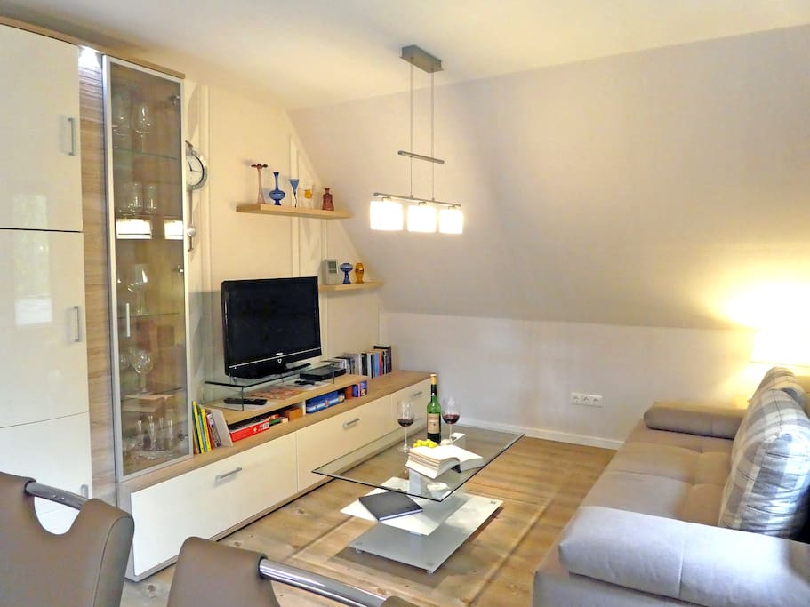 Wohnzimmer mit Sofa das zum Schlafen für 2 Gäste umgebaut werden kann