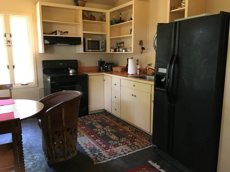 Kitchen with stove, microwave, refrigerator w/ microwave. The kitchen includes all dishes and silverware.