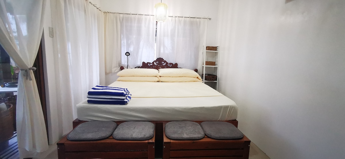 El dormitorio 3 tiene una cama tamaño king. Puede alojar hasta 3 huéspedes. También hay una unidad de aire acondicionado, un televisor y una mesa.