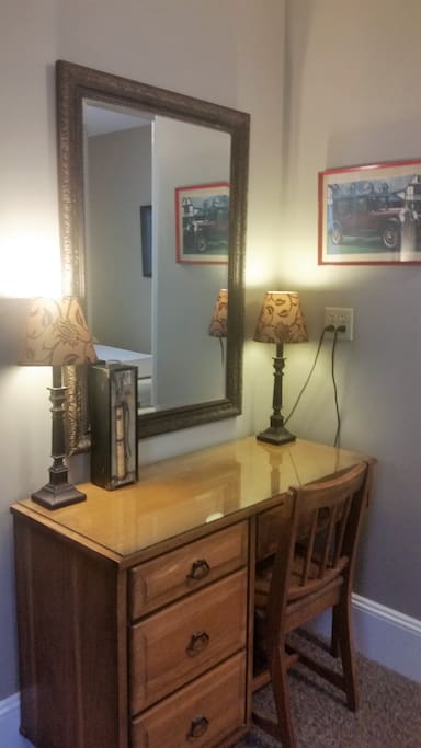 Writing desk with plenty of outlets, glass top and mirror for extra room to "get ready" in the mornings.