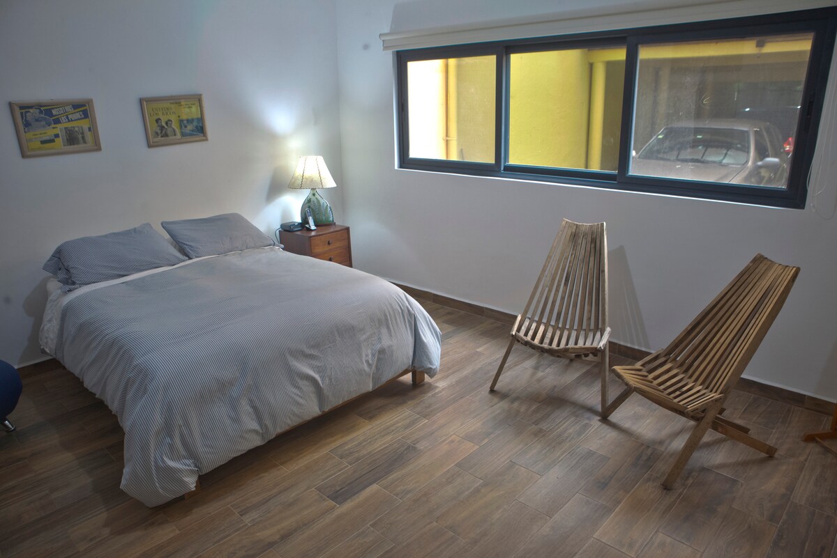 Segundo dormitorio con cama tamaño queen y ventanas grandes con mosquiteros y persianas opacas.