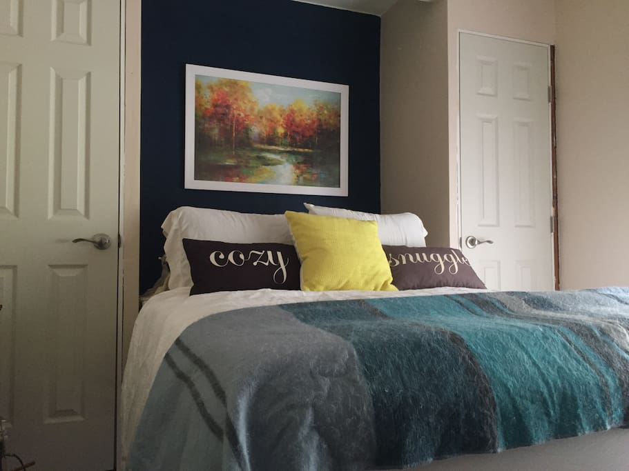 Second bedroom featuring neutral tones and a queen sized bed.