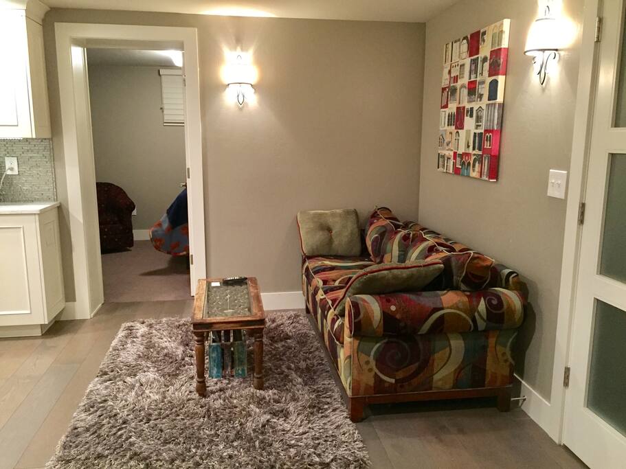 Living room w/small table, couch, kitchen, and basic cable TV