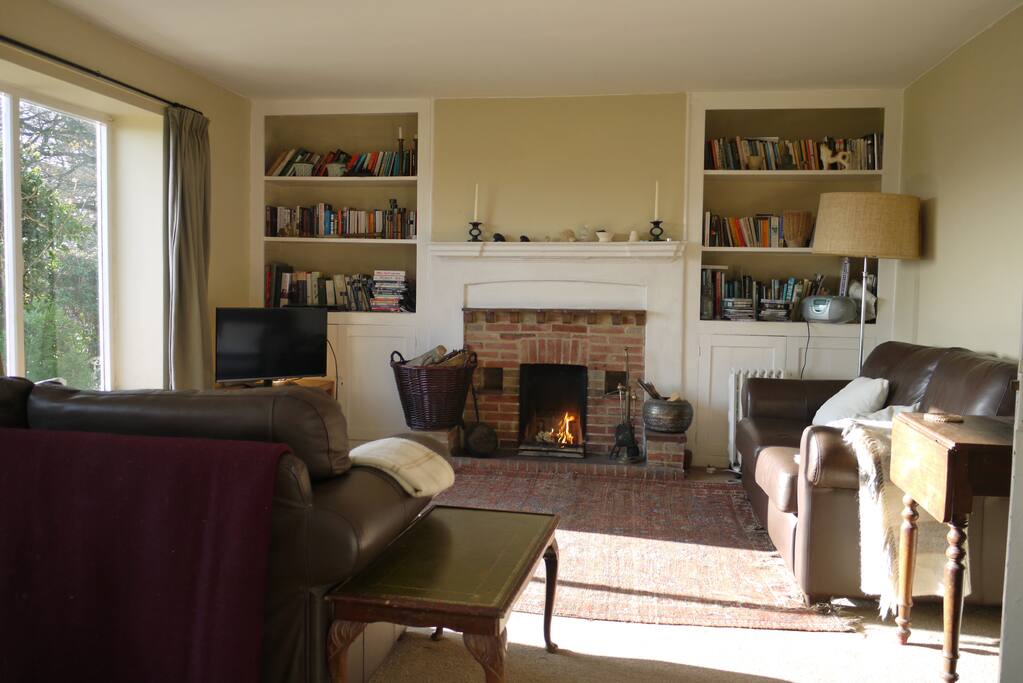 Sitting room with open fire, books, games, TV, local info