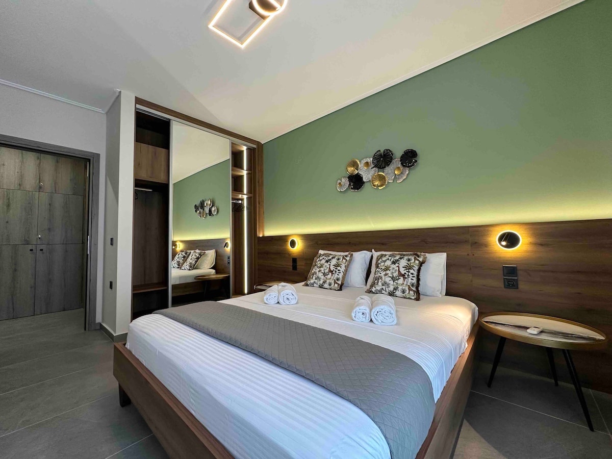 A well-appointed bedroom is highlighted by dual bedside lamps and decorative wall accents. A spacious double bed is complemented by crisp linens and neatly arranged towels. A closet is visible in the background, contributing to the functional design of the room.