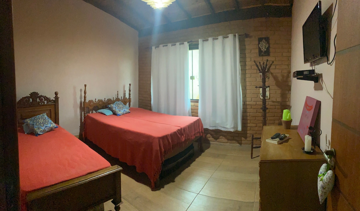 房间有两张床，一张单人床、三个枕头、带Parabolica的电视、衣柜和晾衣架 