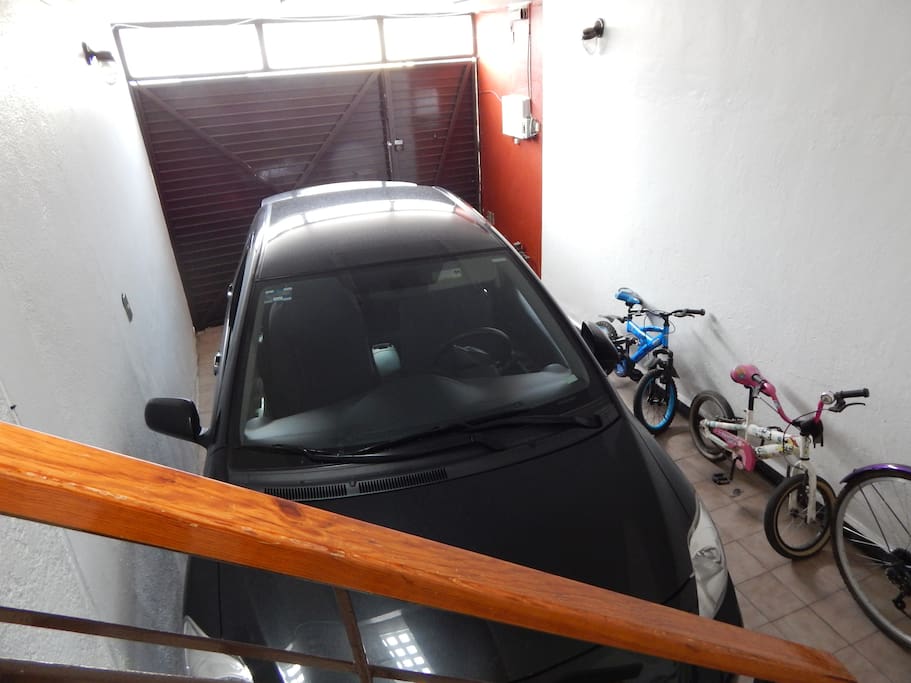 Garaje para 1 vehículo dentro de la casa con portón cerrado.