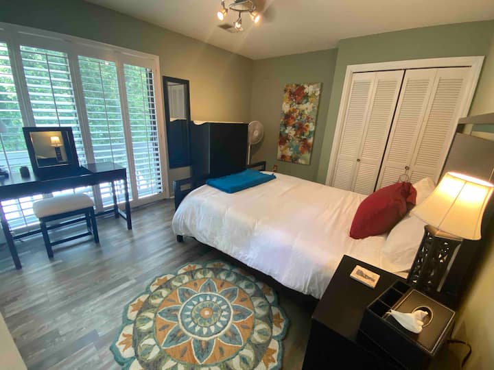 חדר שינה בקומה הראשית עם מיטת קווין סייז וחדר רחצה צמוד פרטי.