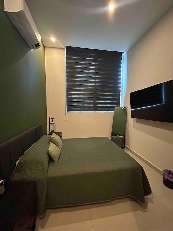 غرفة نوم رئيسية تضم سرير كوين وتلفزيون وميني سبليت. 