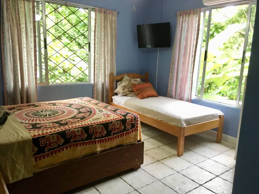 Sleeps three comfortably. Bright airy room with jungle views. Un cuarto claro con vista del bosque. Duermen tres cómodamente.