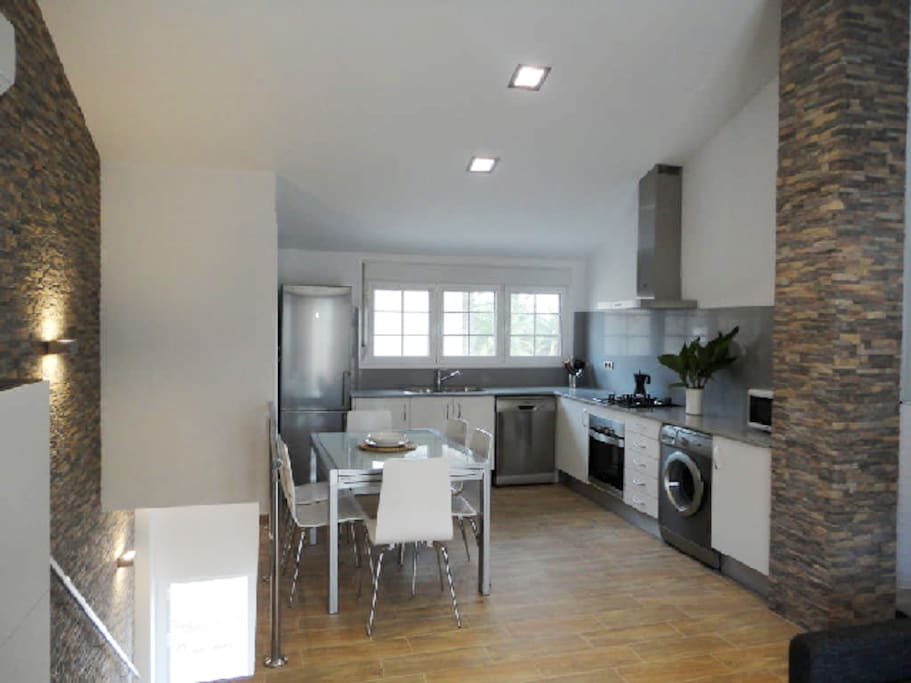 Moderna cocina equipada y comedor con mucha luz