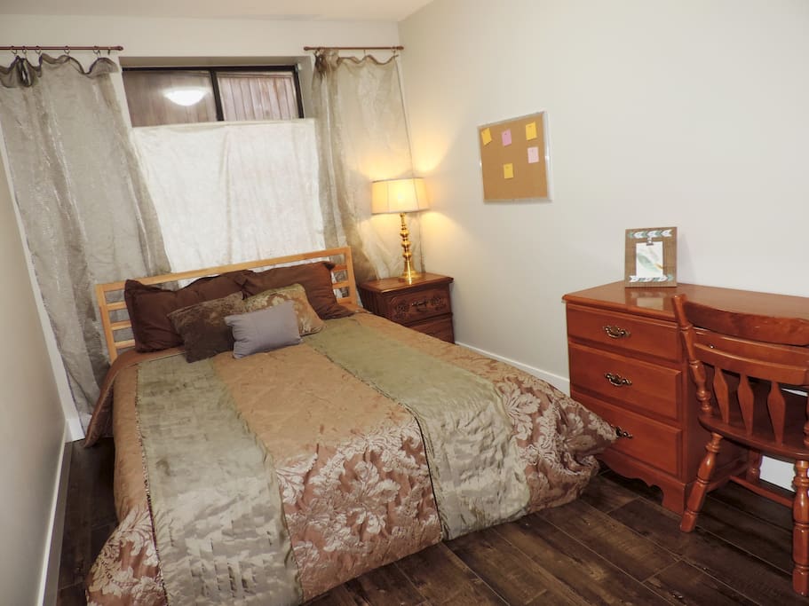Bedroom with queen bed, desk and chair, nightstand and closest