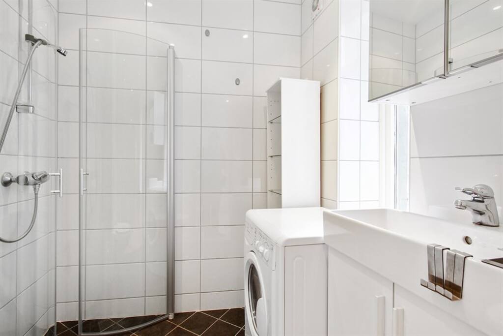 Badet: dusj, toalett, servant, og vaskemaskin