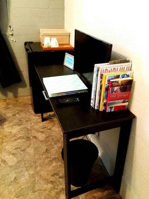 Computer desk with smart TV, reading material, WiFi password, and welcome binder