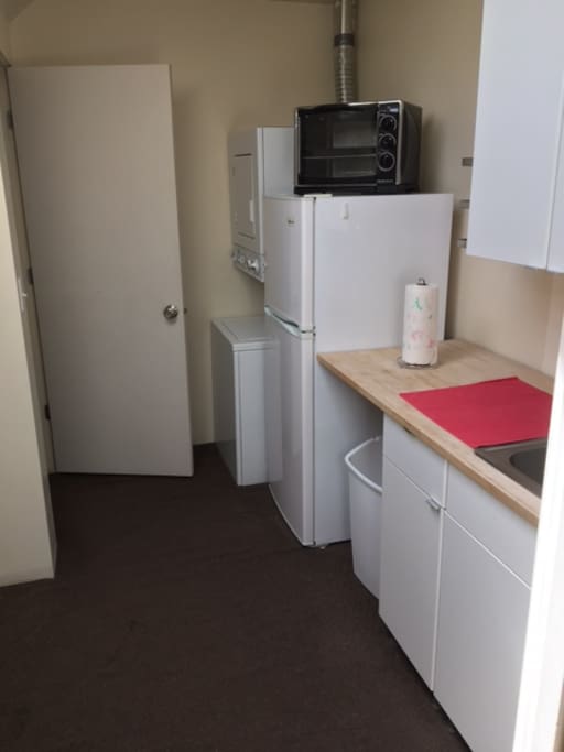 Kitchen with refrigerator/freezer, microwave oven, sink, and washer/dryer
