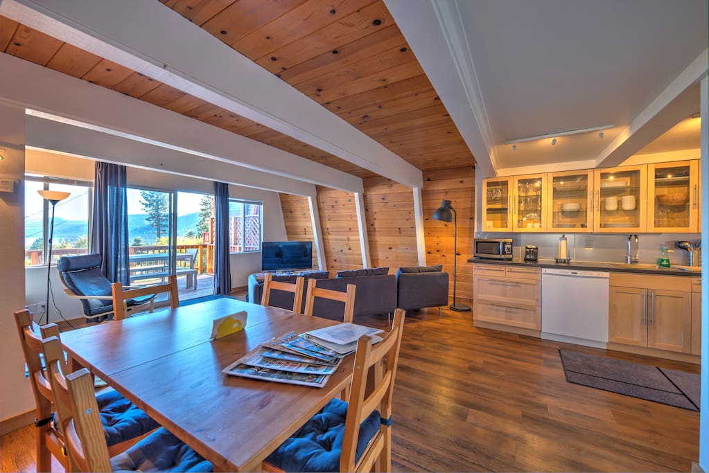 Living room with access to the front deck, dining area, and kitchen