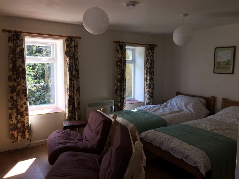 Living room - studio accommodation, twin beds, chairs & t.v & wall heater
