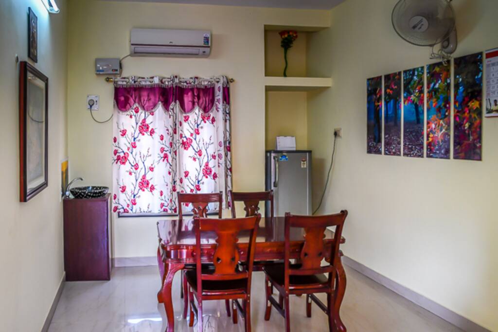 Dining hall with table and four chairs.