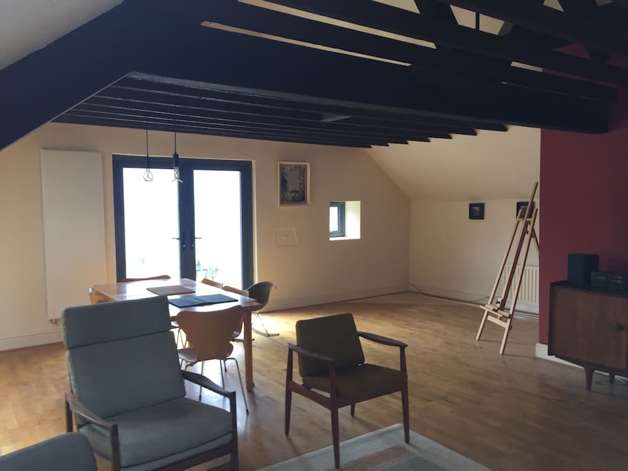 The large open plan top floor with double doors opening onto a sunny balcony.