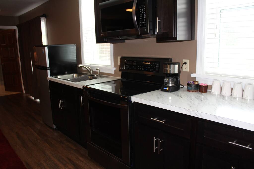 fully stocked kitchen with microwave, range, & fridge