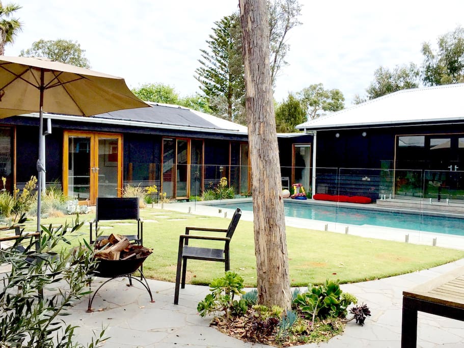View from the kitchen into yard and secure fenced swimming pool. Including fire pit for late night toasted marshmallows.