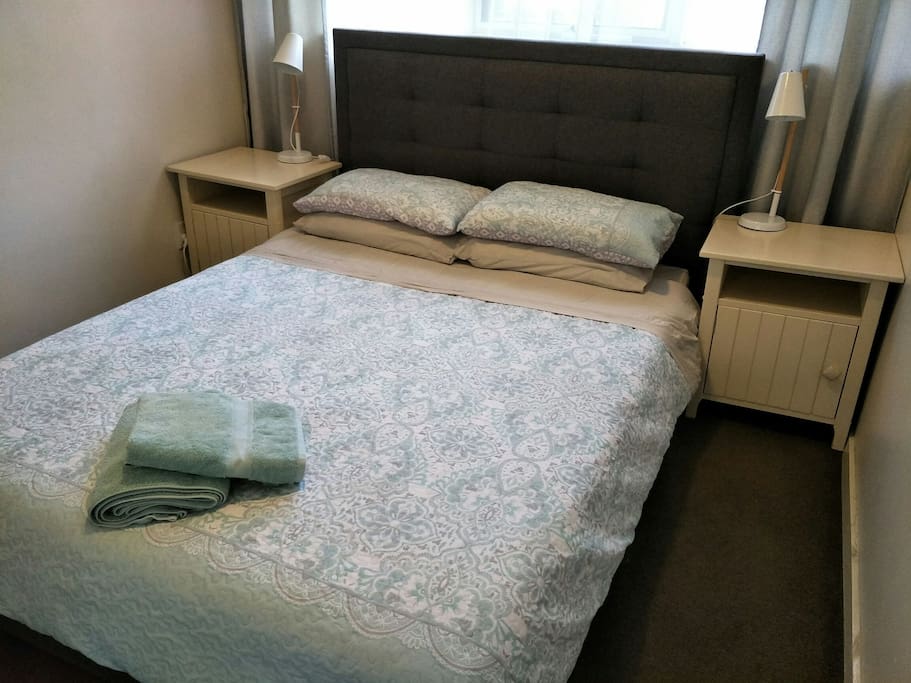 Plush queen sized bed, mirror door wardrobes, bedside tables with lamps.