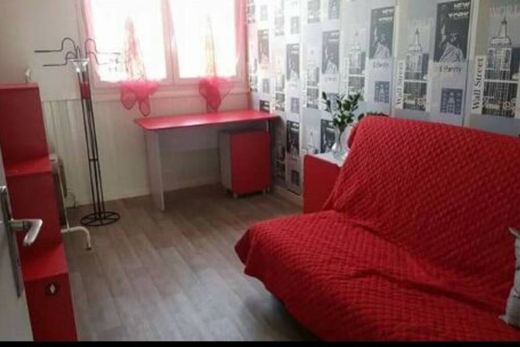 Chambre de 12m2 avec vue sur la ville, comprenant un clic clac pour 2 personnes maximum, un bureau et quelques rangements