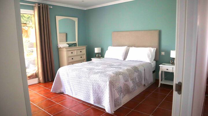 Deuxième chambre avec lit King Size.
Deux tables de chevet avec lampes et penderie,commode.
Dispose de sa propre salle d'eau blanche.