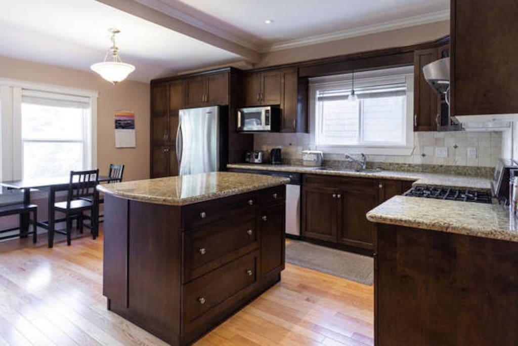 Kitchen with stainless steel appliances, hardwood floor, dishwasher, and gas stove. Breakfast nook seats up to 6.
