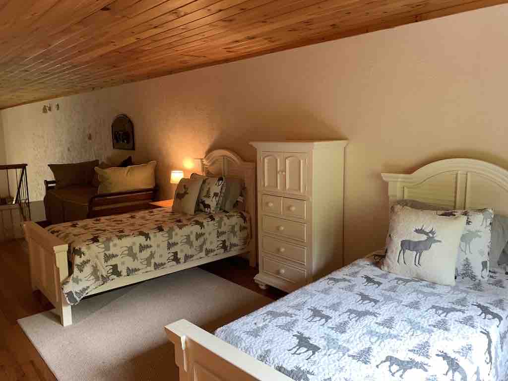 Podkrovie s dvoma oddelenými posteľami a inteligentným televízorom. 