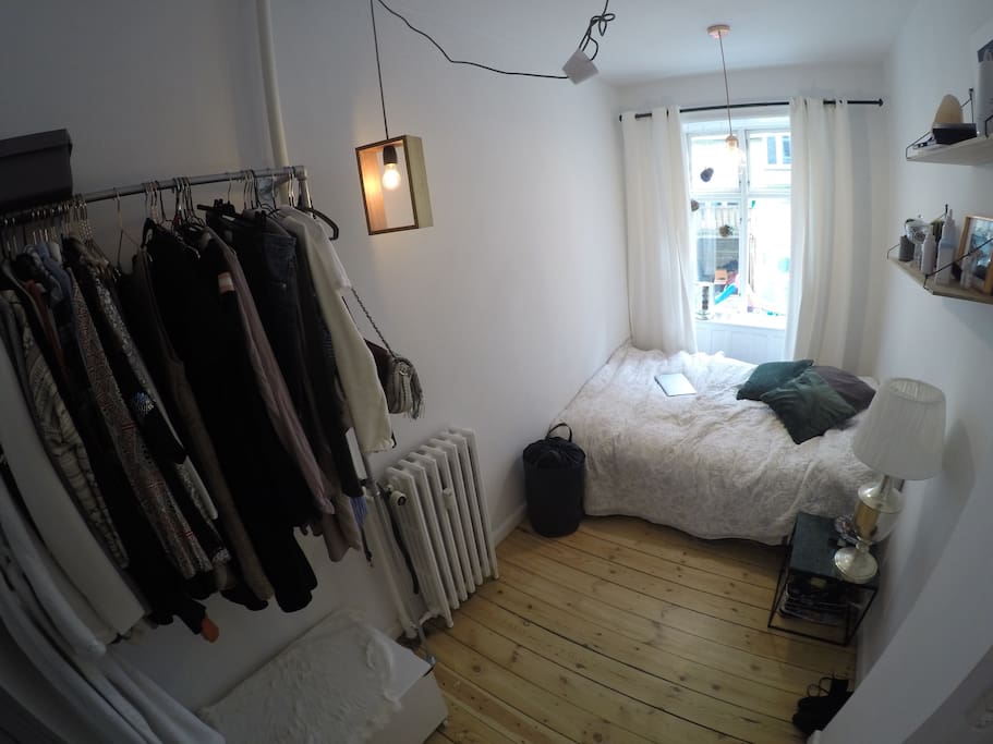 Smaller bedroom, queen sized bed, full length mirror, clothes rack