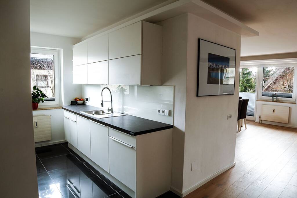 Kitchen leads to large open lounge/dining area and main balcony.