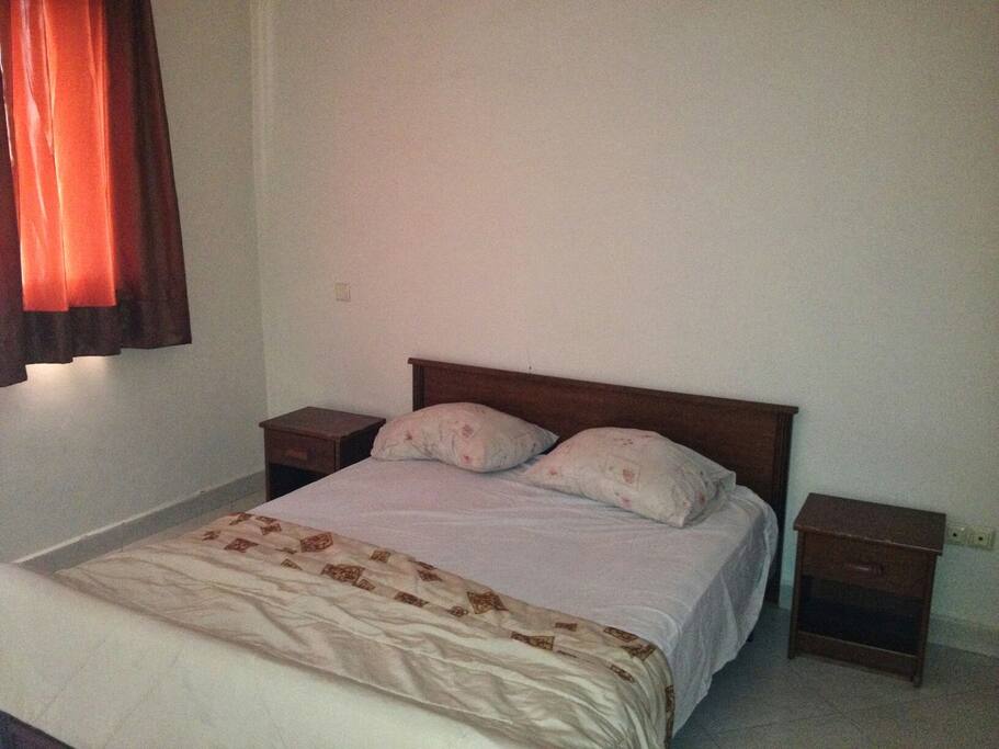 Une chambre climatisée avec placard et double lit