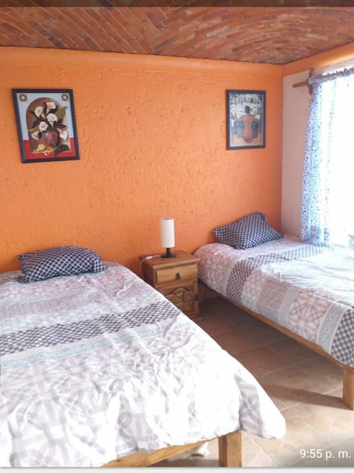 Chumba cha 2 cha kulala kina vitanda 2 vya mtu mmoja na roshani inayoangalia bwawa la miaka mia moja