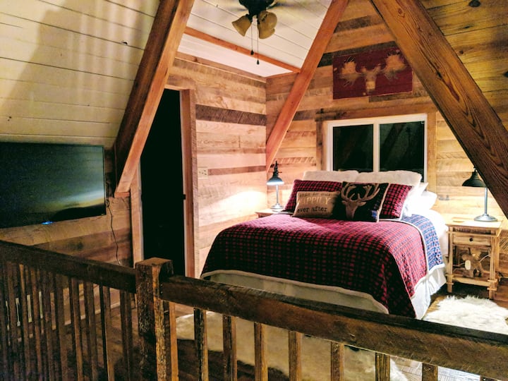 A-frame loft bedroom with timber-frame queen bed