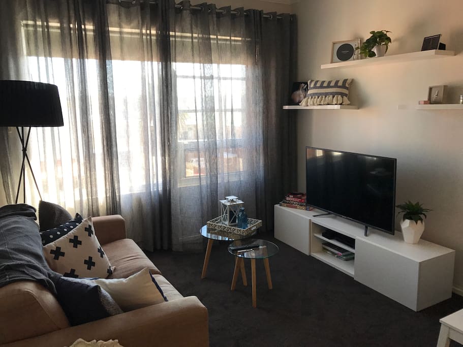 The living room with four person dining table, sofa bed, and TV