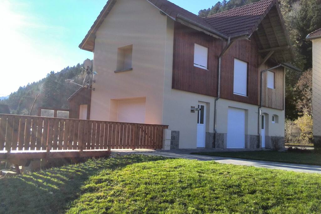 Grande terrasse avec table et 2 banc ,2 chaises longues,parasol, l 'été et barbecue électrique