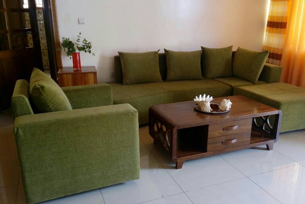 The spacious living room that accomadates 6 people confortably seating, watching a TV that has all local chains and hundred international chains.