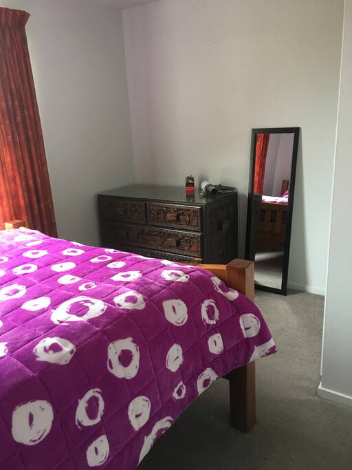 Small room with double bed and wardrobe with shelves