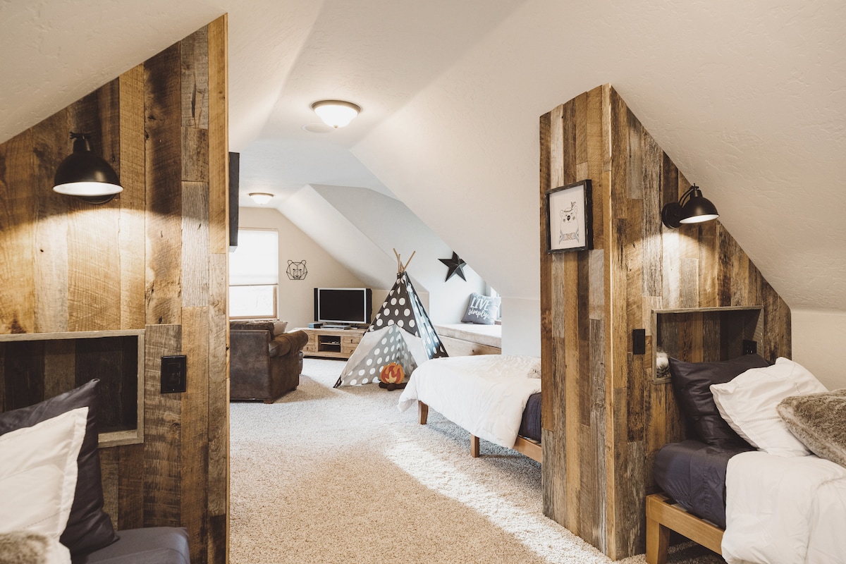 The recently remodeled loft offers 4x twin beds, each with a reclaimed wood headboard, overhead light/sconce, and a personal cubby/shelf with USB outlet.