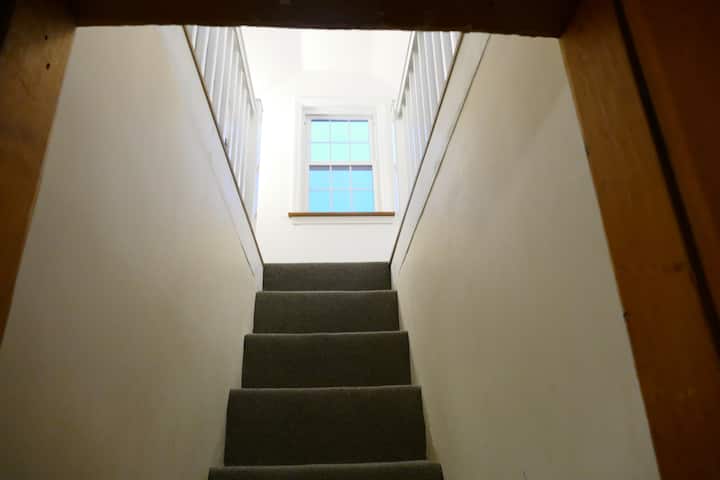 Narrow staircase up to the open, slanted roof second floor.