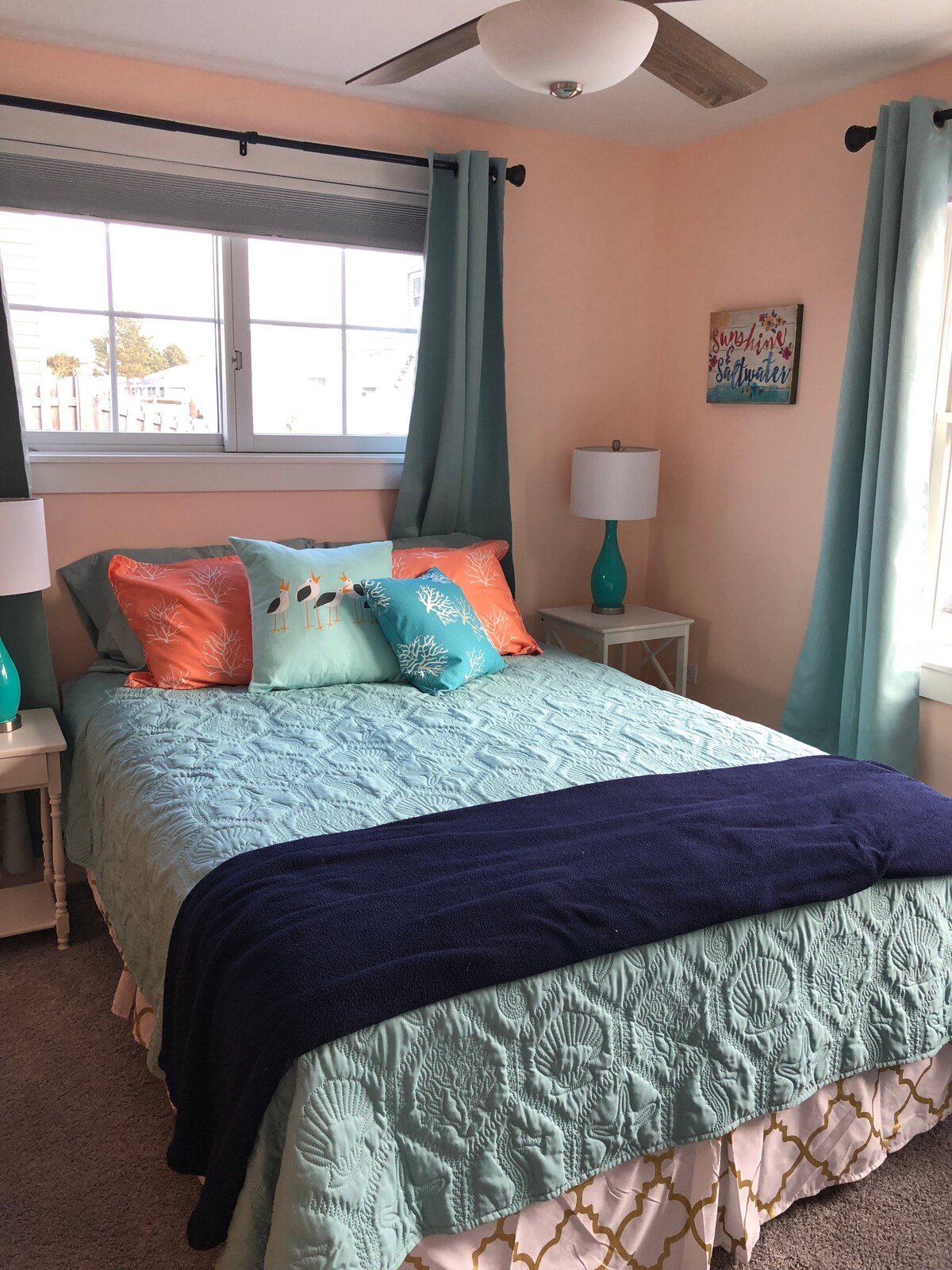 חדר שינה מואר ושטוף שמש עם מיטת קווין סייז