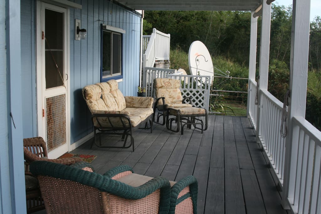 Large covered deck with gliders for relaxing.