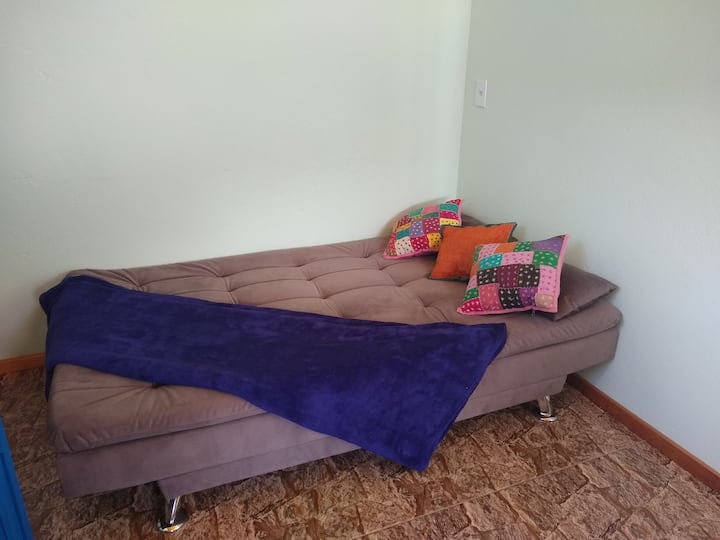 Გასაშლელი დივანი, რომელიც მდებარეობს მისაღებ ოთახში და სამზარეულოსთვის ღია კონცეფციით.