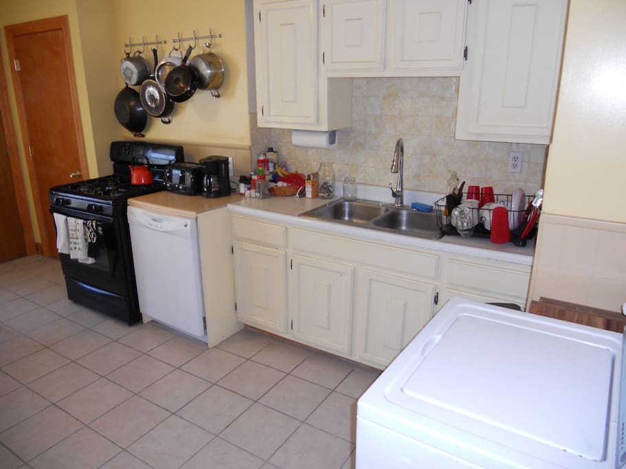 Kitchen with washer. There is a clothes line for drying.