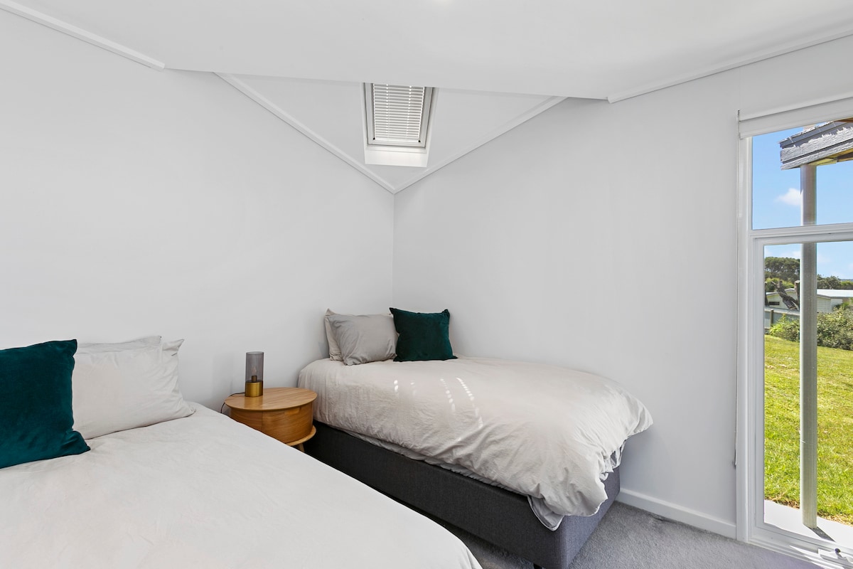 Спална соба со брачни кревети свртени кон дворот 