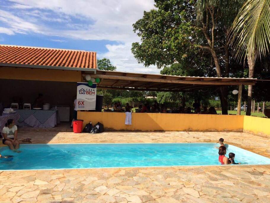 Área de lazer. Contém a piscina um banheiro e churrasqueira, fogao, pia e freezer.
